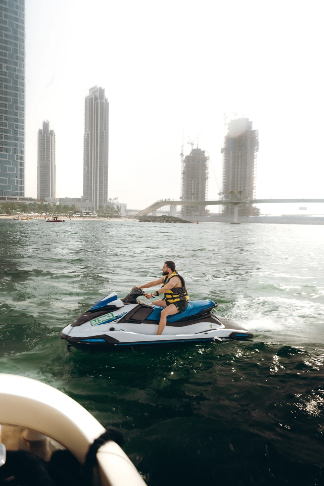 Zack Lalouti seated on a jet ski with waterfront towers behind him in Dubai.