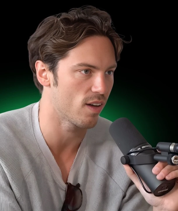 Greg O'Gallagher wearing a light collared shirt during an interview.